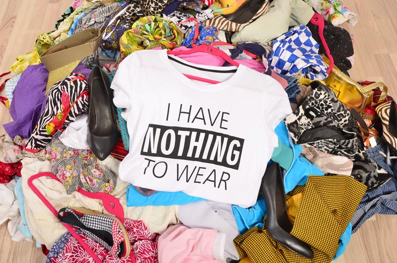 Close up on a untidy cluttered wardrobe with colorful clothes and accessories, many clothes and nothing to wear.