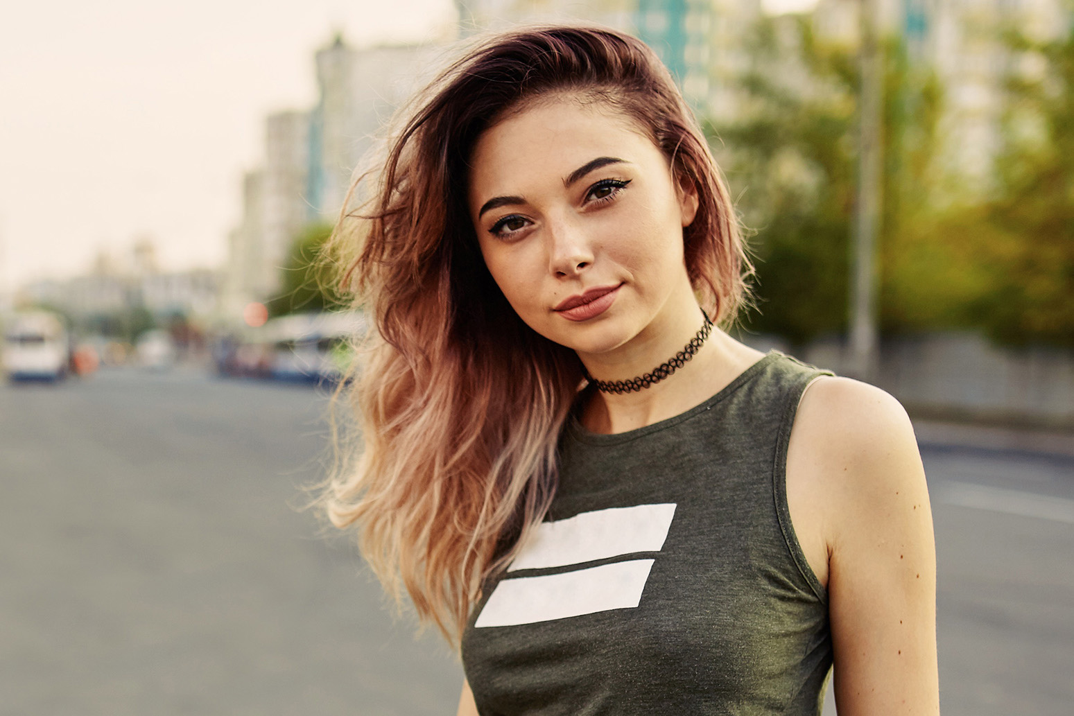 Beautiful young tattooed woman with his longboard on the road in the city in sunny weather