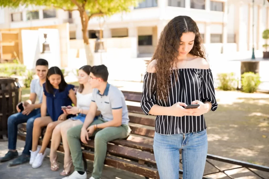 Young adult with self esteem issues doesn't talk to friends at social gathering.