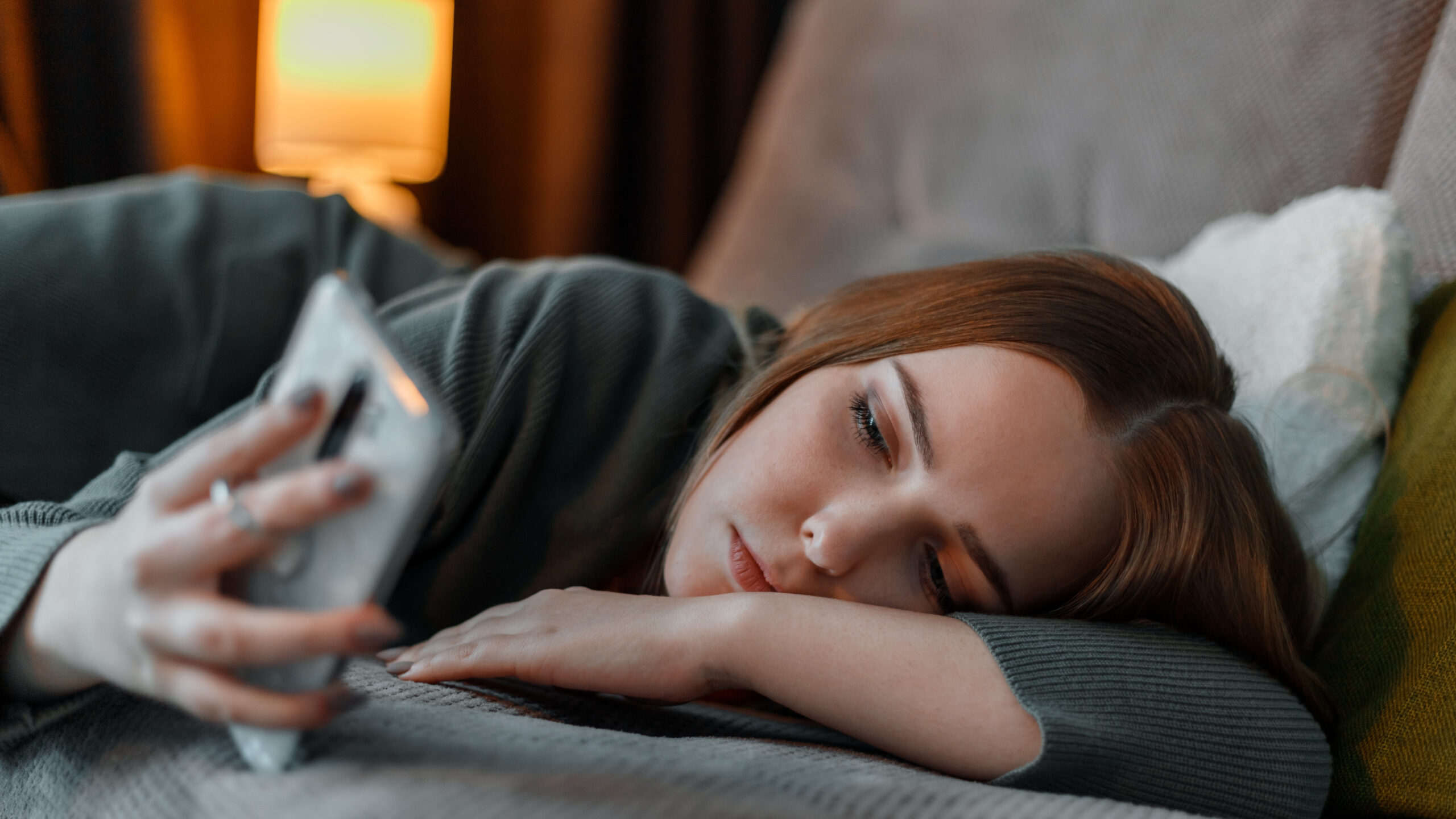 Teen girl struggling with screen addiction scrolls through social media on phone. Teen girl struggling with screen addiction scrolls through social media on phone.
